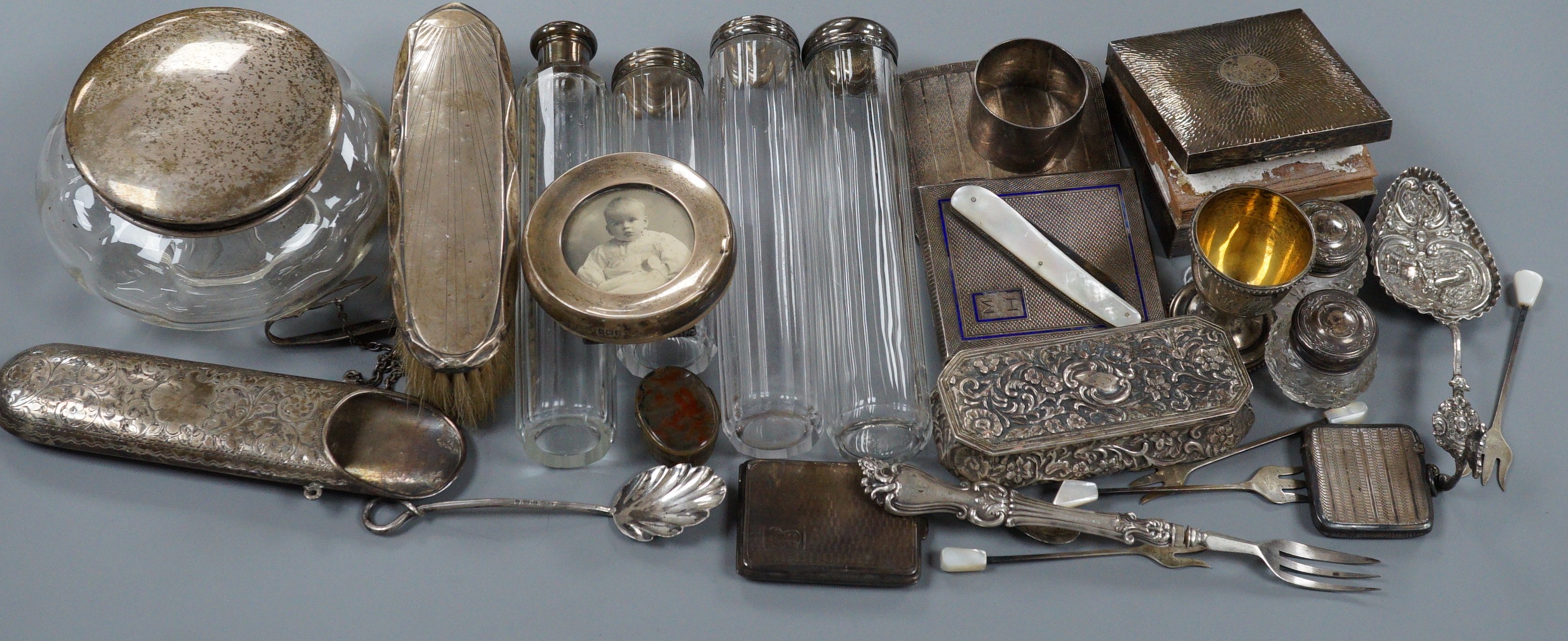 A collection of assorted collectable silver items, including a George V spectacles case, cigarette box, trinket box, Dutch spoon, mounted glass power jar, egg cup, enamelled cigarette case, vesta case, fruit knife, napki